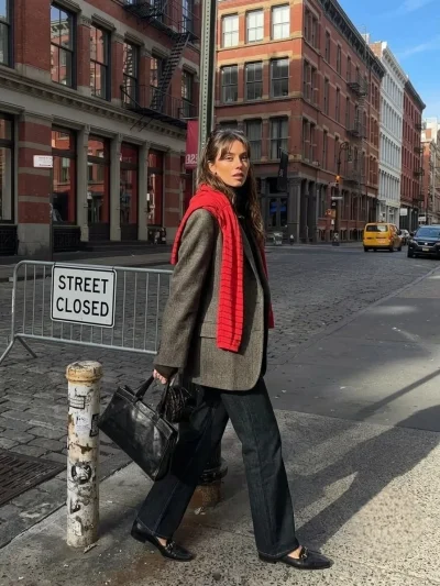 A woman wearing a dark jeans and cardigan fall outfit